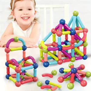 Niña sonriente jugando con palos imantados de colores, construyendo figuras