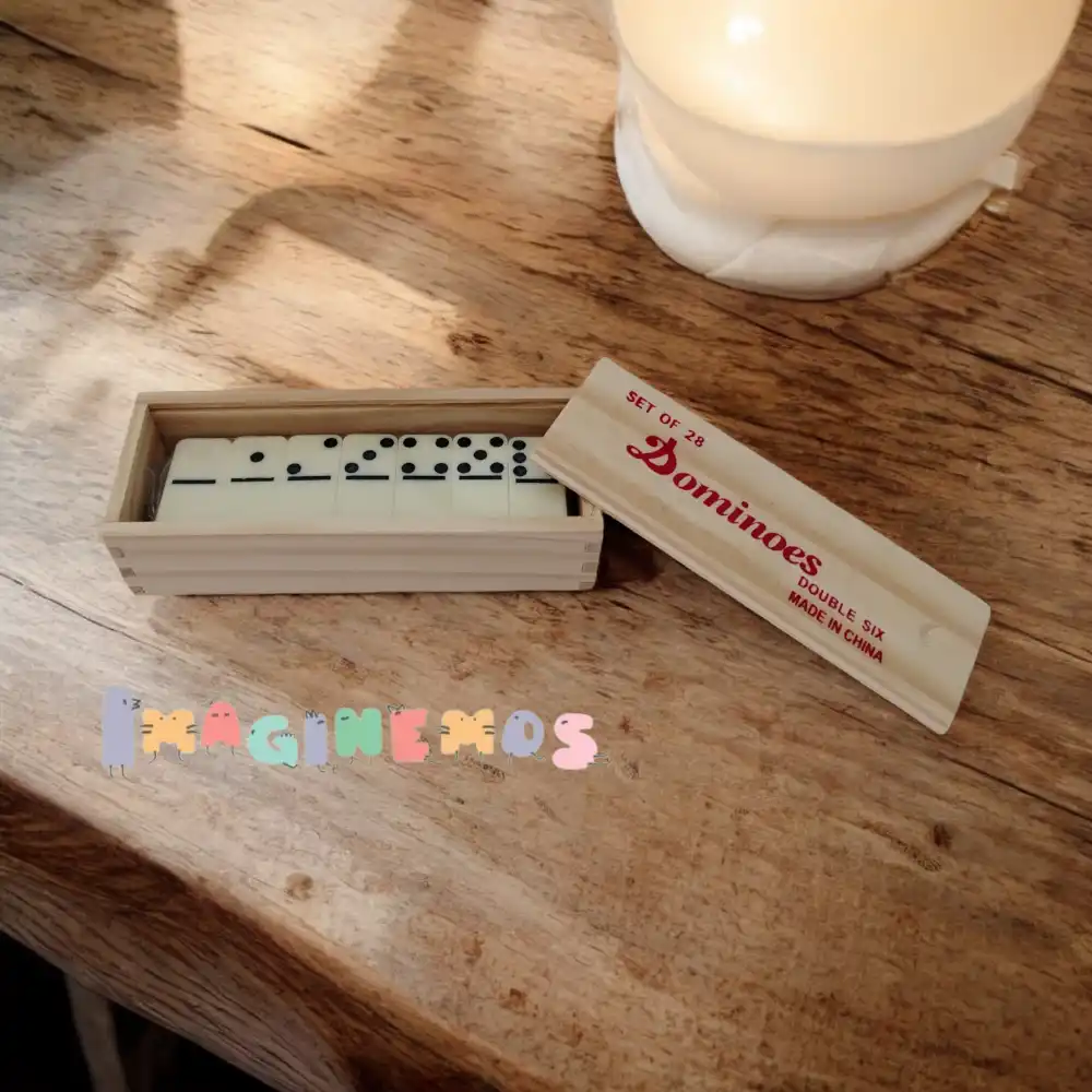 Dominó de madera en estuche rectangular con tapa deslizable, mostrando las fichas ordenadas sobre una mesa.