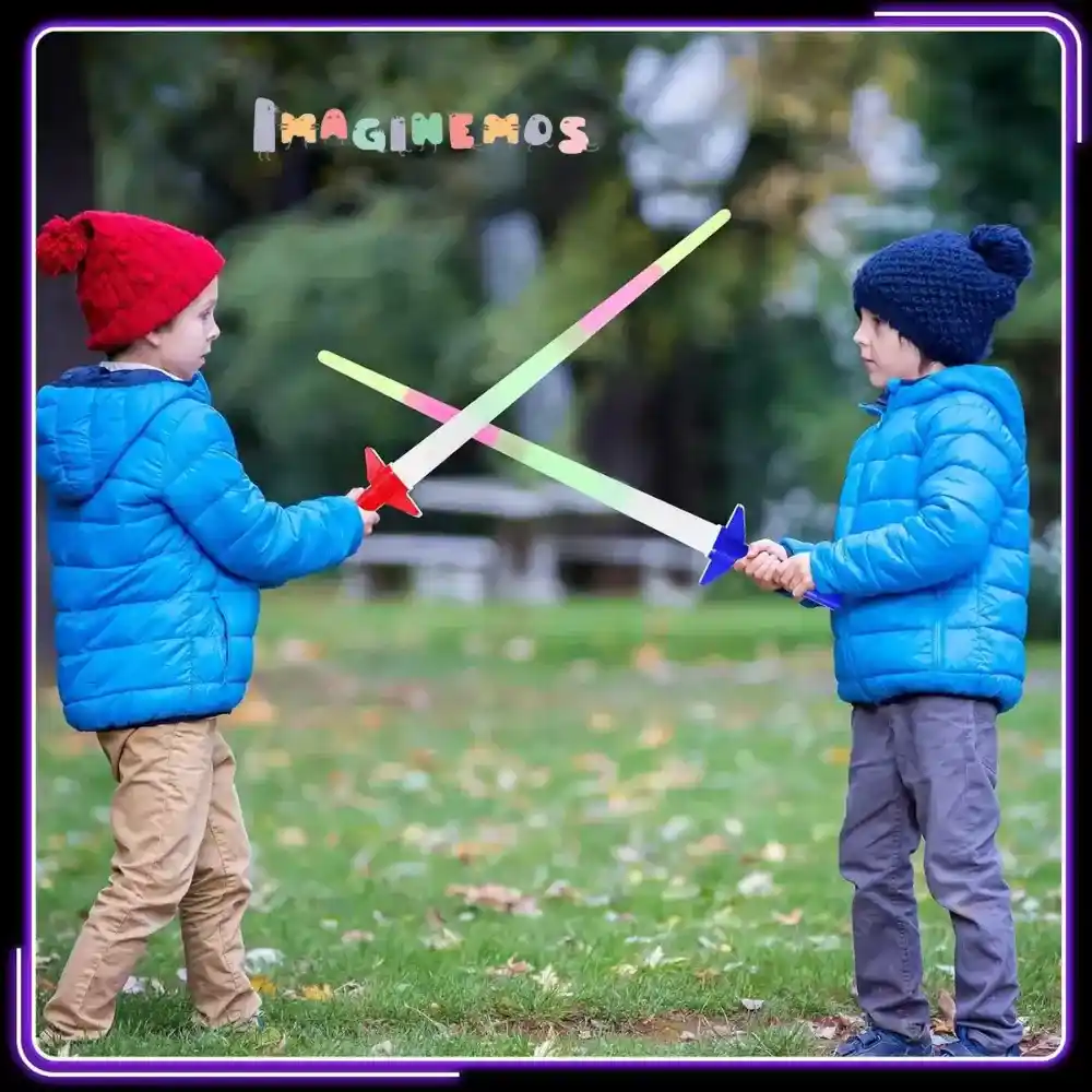 Dos niños jugando en el parque con espadas luminosas LED, cruzándolas mientras se divierten al aire libre.