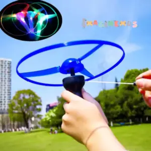 Platillo volador azul con luz LED siendo lanzado con un propulsor manual en un parque al aire libre.